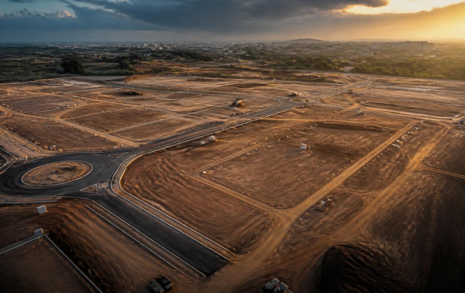 Aerial view of land being planned and prepared for property development at sunset
